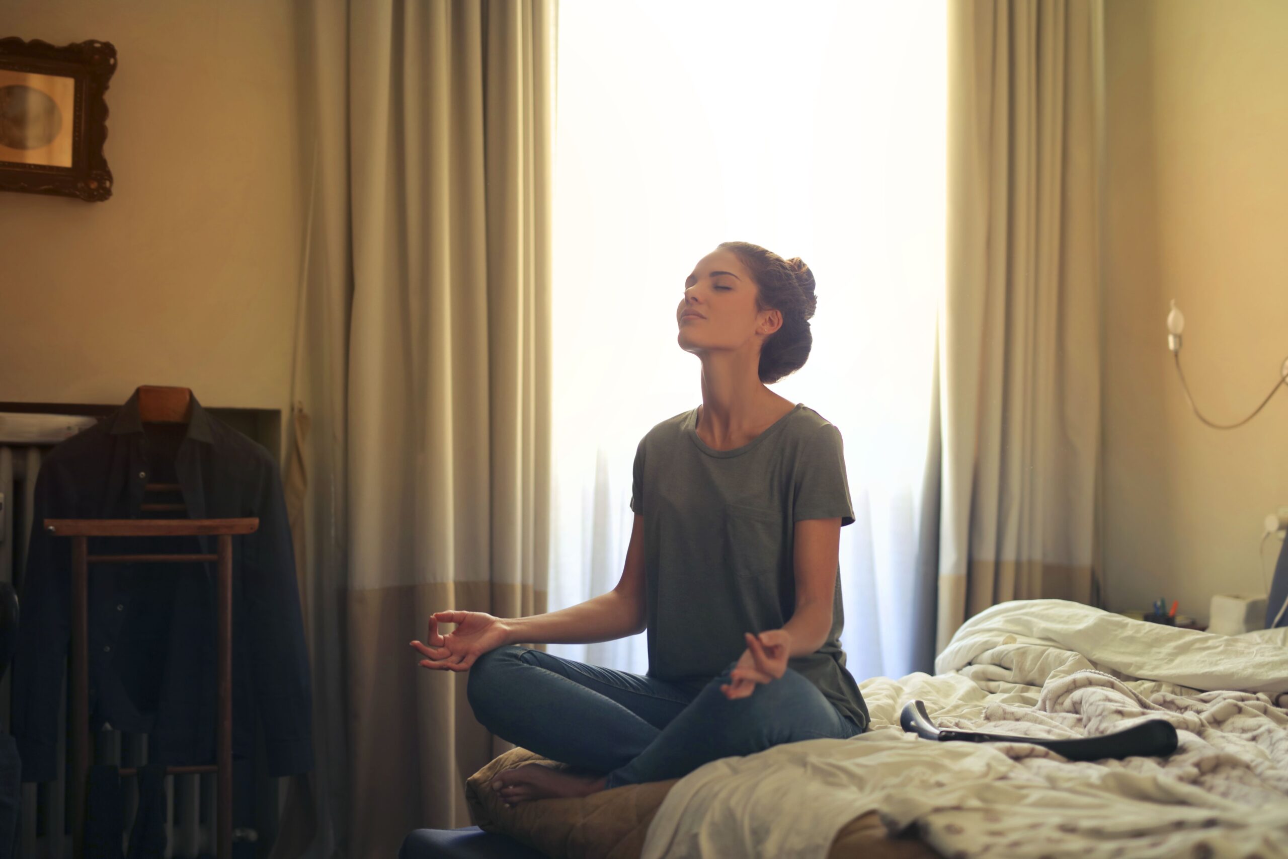 Woman meditating in a calm bedroom